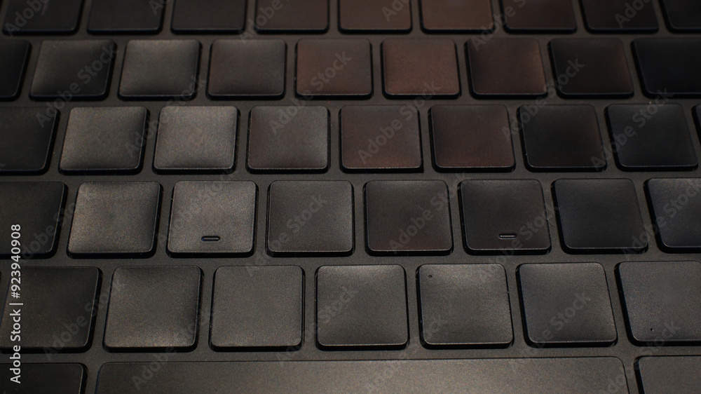 Closeup of a sleek, modern laptop keyboard with dark keys in low light. Perfect for tech, business, or productivity concepts. Closeup of a sleek, modern laptop keyboard with dark keys in low light. Perfect for tech, business, or productivity concepts.