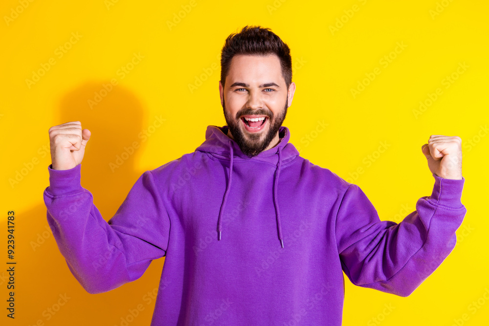 Photo of cheerful attractive lucky man wear purple trendy clothes rejoice win power strength isolated on yellow color background Photo of cheerful attractive lucky man wear purple trendy clothes rejoice win power strength isolated on yellow color background
