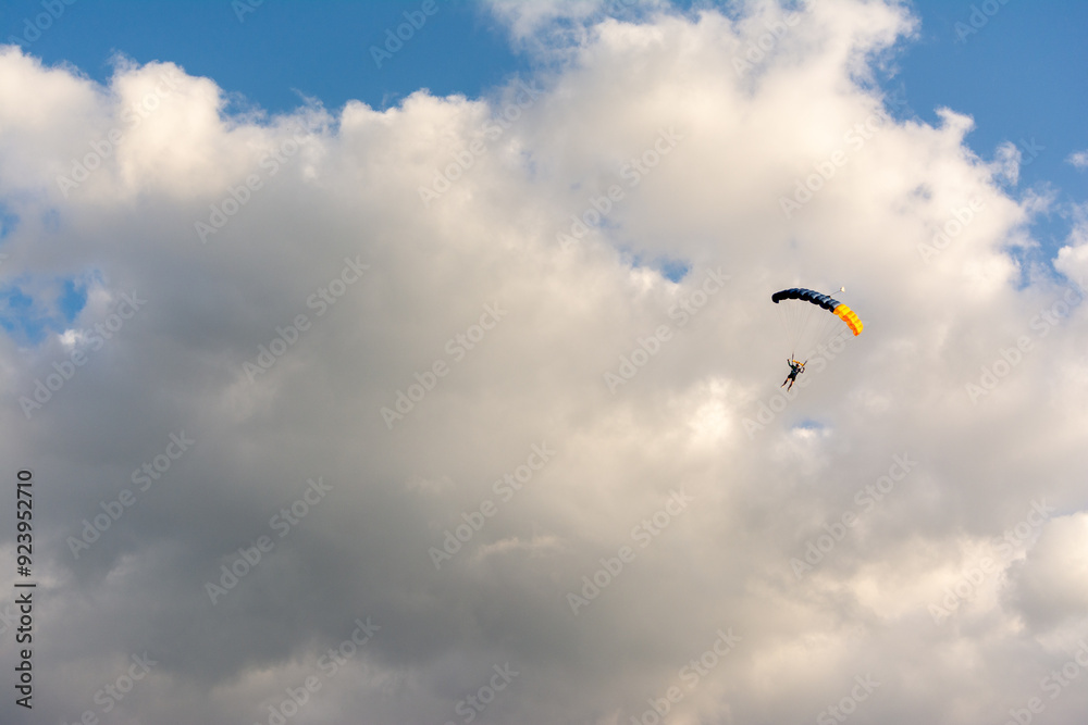 Parachuter with red canopy on cloudy sky Parachuter with red canopy on cloudy sky