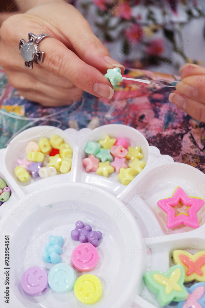 Fingers Putting a Bead on String for Making Beaded Accessories Fingers Putting a Bead on String for Making Beaded Accessories