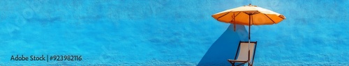 Beach Chair and Umbrella on a Blue Wall Background with Duplicate Space, a Clean and Text-Friendly Image Perfect for Blog Posts.