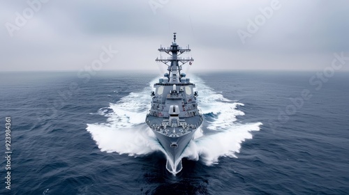 A large navy ship is sailing through the ocean photo