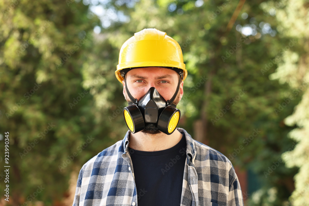 Man in respirator mask and hard hat outdoors. Safety equipment Man in respirator mask and hard hat outdoors. Safety equipment