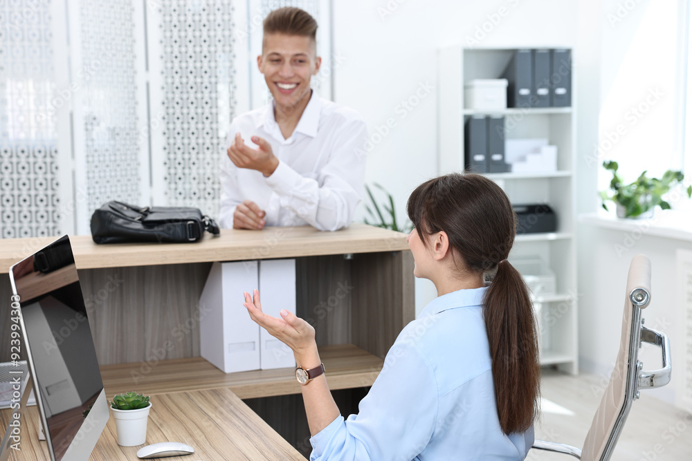 Professional receptionist working with client in office Professional receptionist working with client in office