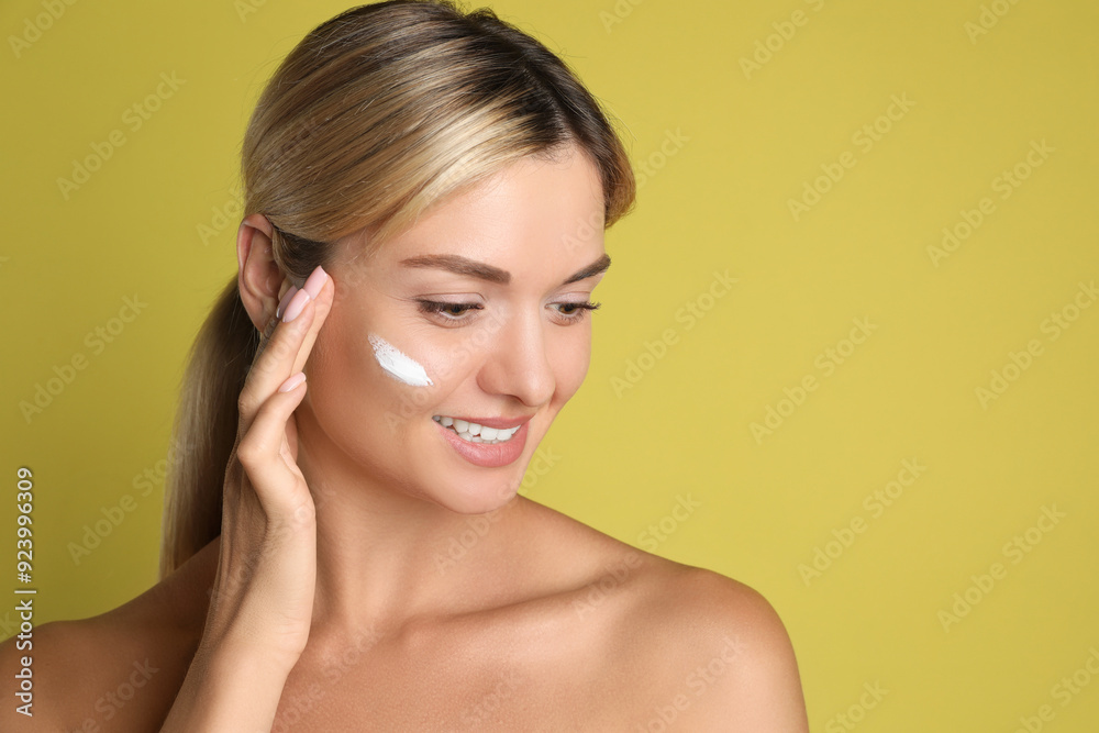 Beautiful woman with cream on her face against olive background, space for text Beautiful woman with cream on her face against olive background, space for text