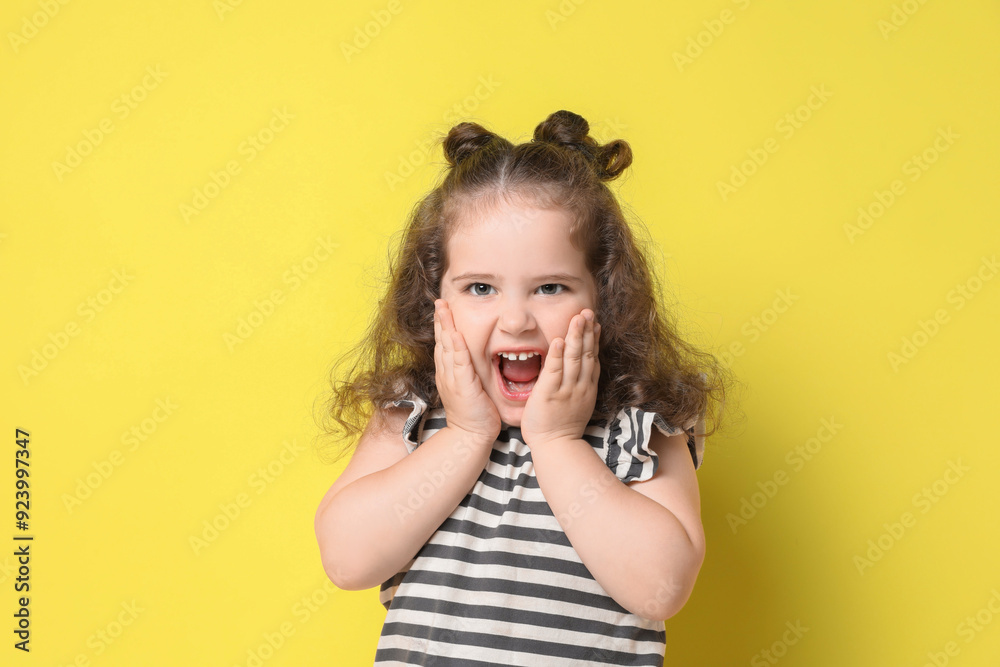 Portrait of happy girl on yellow background. Adorable child Portrait of happy girl on yellow background. Adorable child