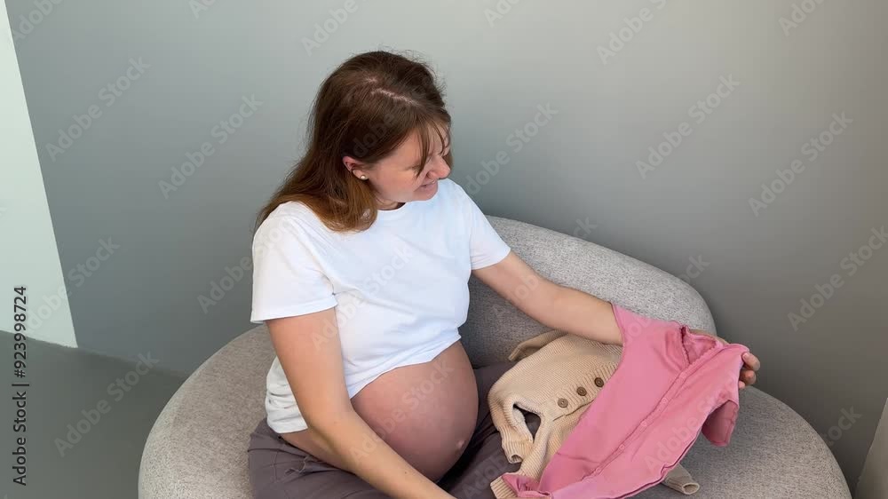 Happy pregnant woman holding baby clothes, prepare for the child Stock ビデオ | Adobe Stock