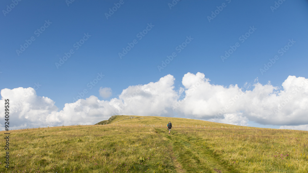 randonneur sur le GR400, le tour des monts du Cantal en été, avec vue sur les volcans cantaliens autour du Puy Gros randonneur sur le GR400, le tour des monts du Cantal en été, avec vue sur les volcans cantaliens autour du Puy Gros