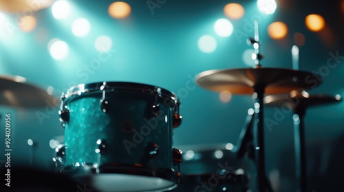 This image captures a drum set on stage with lights shining in the background, creating an atmospheric and moody setting perfect for a musical performance.