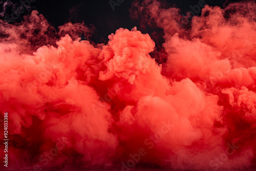 A dramatic burst of red smoke expands against a solid black background, creating a striking contrast. The swirling, cloud like formation captures the dynamic motion and intensity of the explosion.