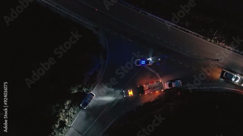 night Fatal road accident. police flashing lights. Roadside assistance loads wrecked car, police officer direct traffic