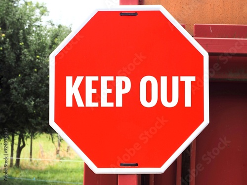 A close-up view of a red hexagonal warning stop sign on a door of a private property, with the words Keep Out, emphasizing restricted access and no trespassing photo