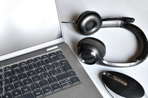 Working place  with laptop, headphones and computer mouse on white office desk.