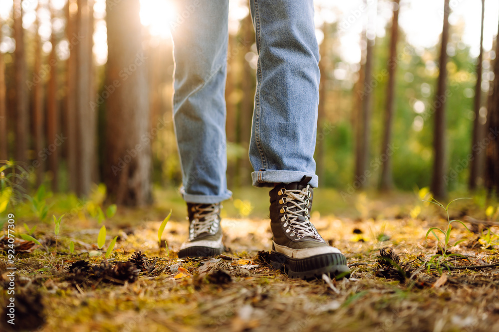 Feet of an adult wearing boots to travel walking in the forest. Feet walking in outdoor nature. Healthy lifestyle on leisure activity. Feet of an adult wearing boots to travel walking in the forest. Feet walking in outdoor nature. Healthy lifestyle on leisure activity.