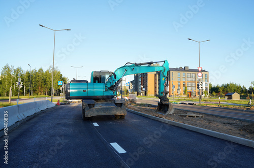 Excavator on road construction. Screeding ground for installing borders, curbs concrete blocks at road. Roadworks, construction site. Bucket wheel excavator on road construction at construction site.