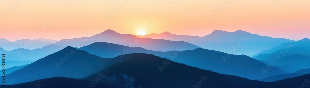 Obraz premium Serene mountain landscape at sunrise with layers of blue hills and a warm, glowing horizon. Perfect for nature, travel, and scenic themes.