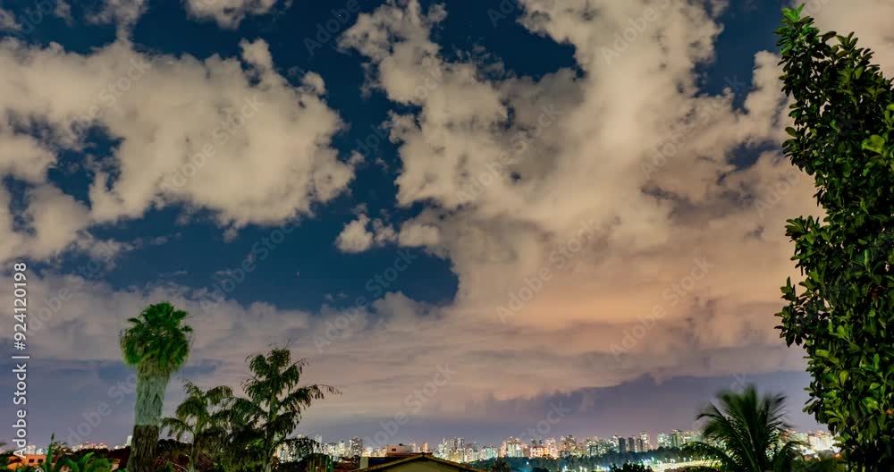 Timelapse noturno de nuvens, estrelas e cidade ao fundo