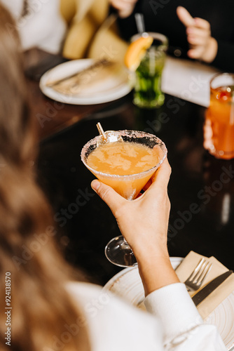 Enjoying a refreshing cocktail during a cozy gathering with friends at a stylish restaurant