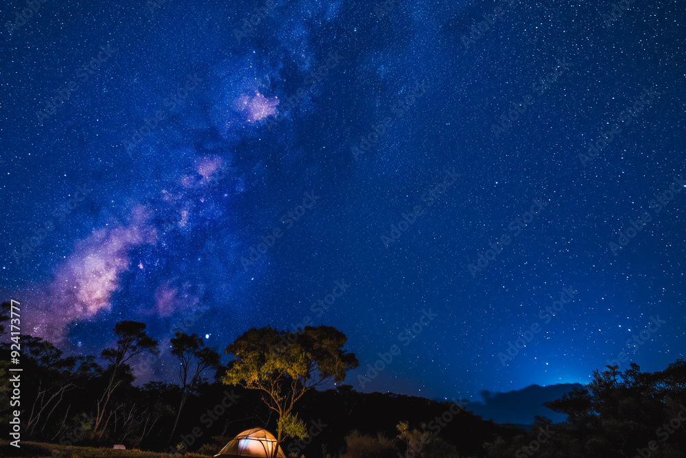 Naklejka premium A tent pitched under a starry night sky with the Milky Way visible.