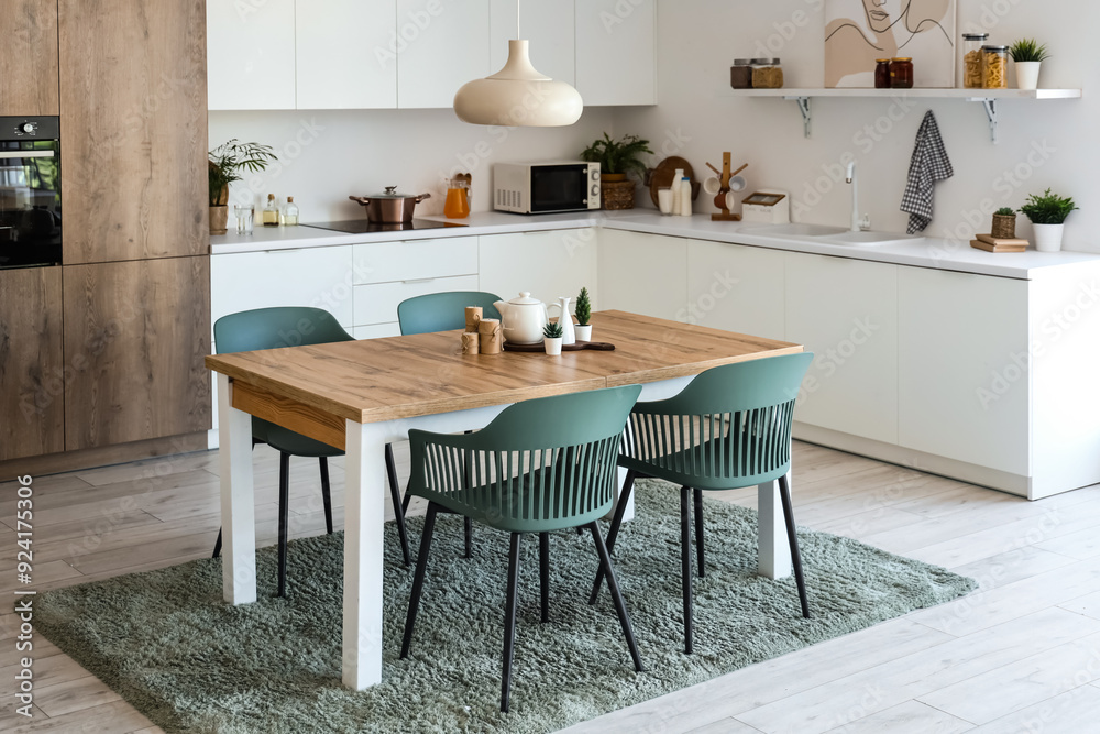 Interior of light kitchen with dining table and white counters Interior of light kitchen with dining table and white counters