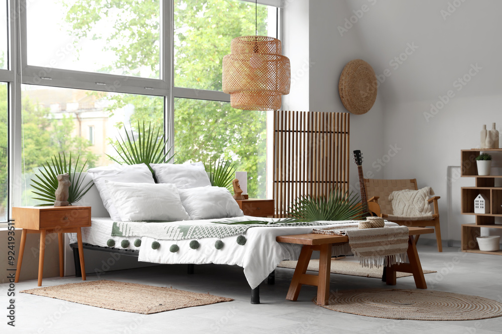 © Pixel-Shot - Comfortable bed decorated with palm branches near large window in bedroom © Pixel-Shot - Comfortable bed decorated with palm branches near large window in bedroom