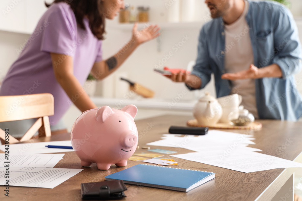 © Pixel-Shot - Piggy bank on table of couple in debt in kitchen. Bankruptcy concept © Pixel-Shot - Piggy bank on table of couple in debt in kitchen. Bankruptcy concept