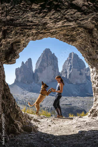 Girl and dog in the mountai, Views from the cave to the three picks, Dolomites, Italy