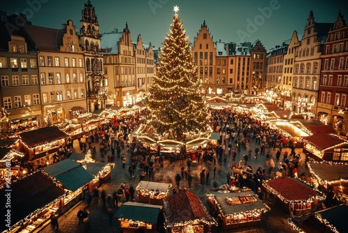 Crowded Christmas market in a historic town square with large illuminated tree photo