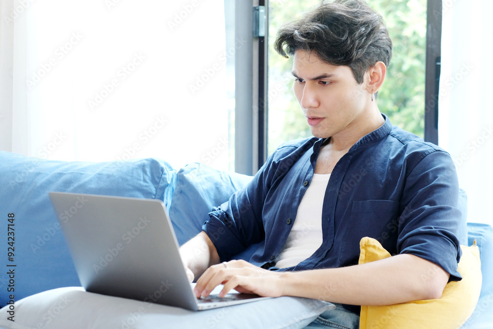 Young man working with laptop computer at home, work from home, online learning