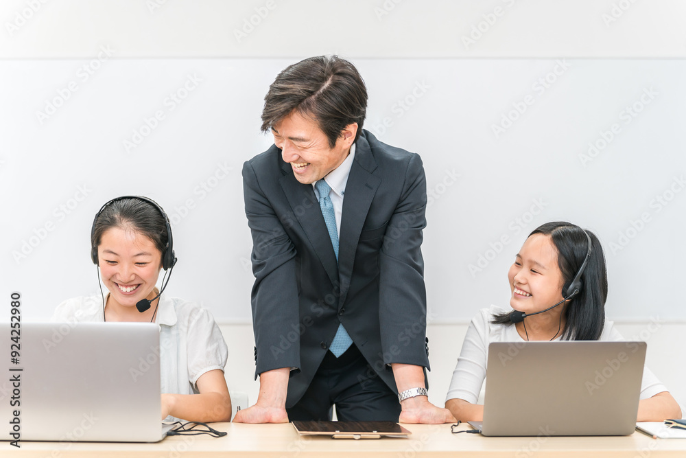 学校の授業・塾でで英会話のリスニング・ヒアリングレッスンをする先生・教師と子供（女の子・日本人）
