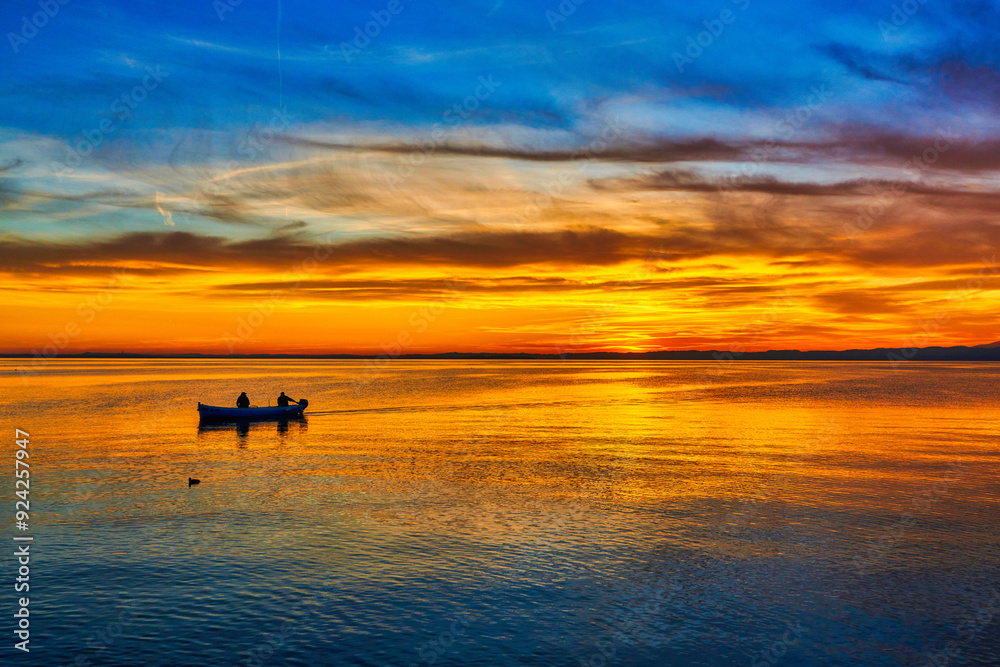 View of the beautiful Lake Garda surrounded by mountains, Scenic view of sunset at Lake Garda in the evening with the beautiful sunset colors, italy View of the beautiful Lake Garda surrounded by mountains, Scenic view of sunset at Lake Garda in the evening with the beautiful sunset colors, italy