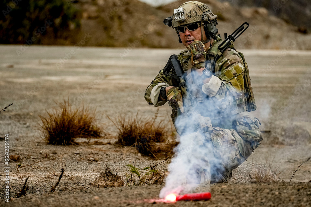 Naklejka premium A group of military men in combat gear patrol in the middle of a desert and tropical jungle. Soldiers in full combat gear in dry weather conditions assemble and march on a mission.