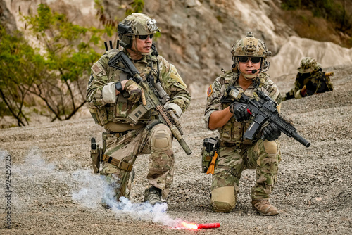 A group of military men in combat gear patrol in the middle of a desert and tropical jungle. Soldiers in full combat gear in dry weather conditions assemble and march on a mission.