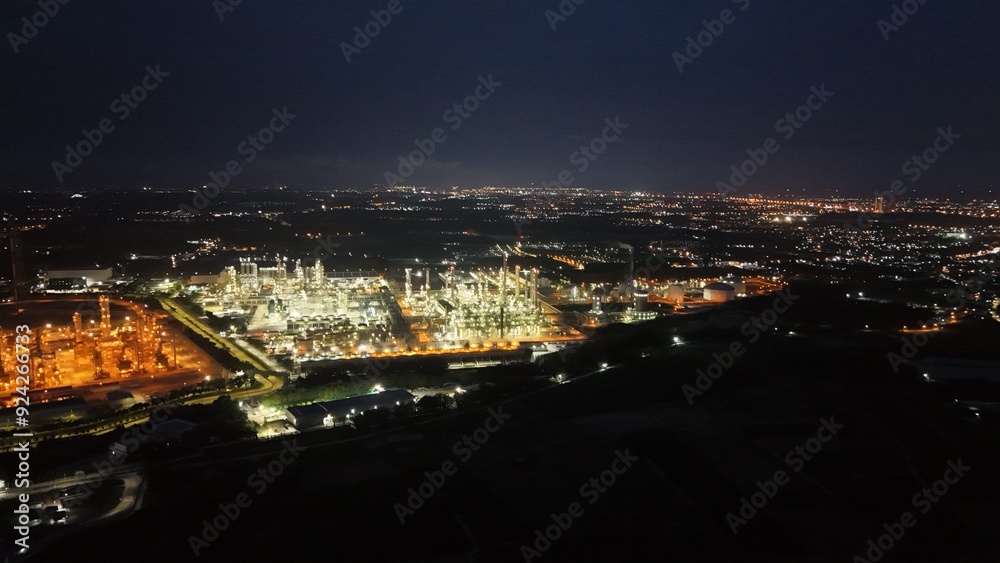 Fototapeta premium High angle view of industrial plant with pipes and tanks for mixing chemicals and gases at night.