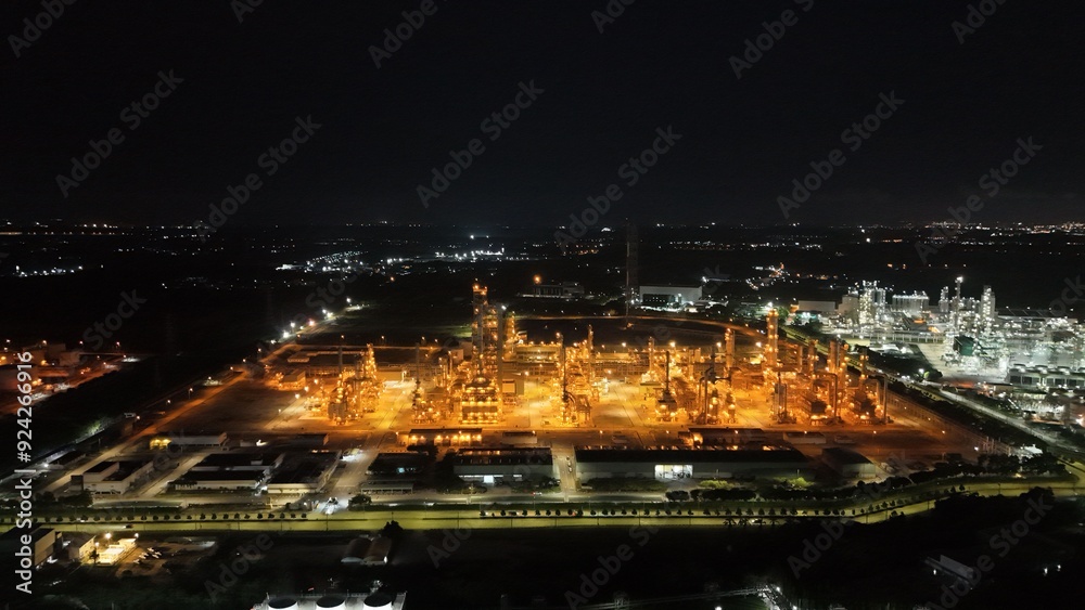 High angle view of industrial plant with pipes and tanks for mixing chemicals and gases at night. High angle view of industrial plant with pipes and tanks for mixing chemicals and gases at night.