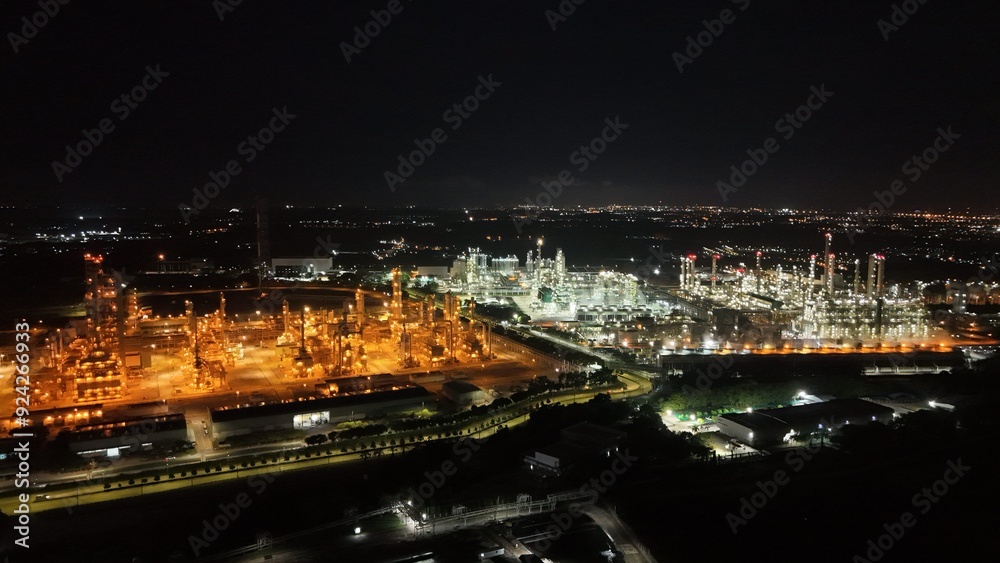 High angle view of industrial plant with pipes and tanks for mixing chemicals and gases at night. High angle view of industrial plant with pipes and tanks for mixing chemicals and gases at night.