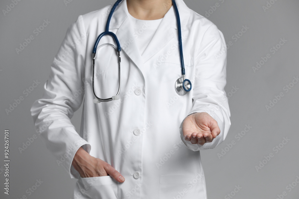 Doctor holding something on grey background, closeup Doctor holding something on grey background, closeup