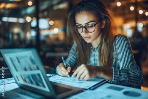 Woman engrossed in research at a library surrounded by stacks of books and a focused atmosphere