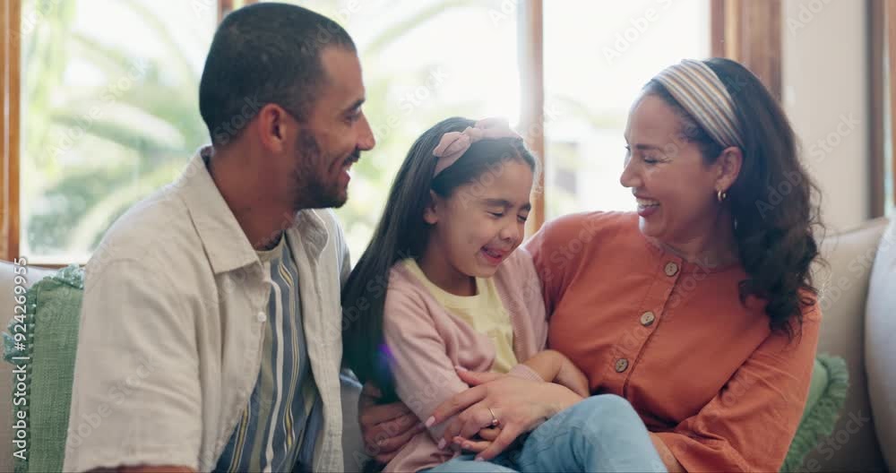 Family, love and parents tickling their daughter on a sofa in the living room of their home together. Smile, energy or fun with a mother, father and girl child playing in their apartment for bonding Family, love and parents tickling their daughter on a sofa in the living room of their home together. Smile, energy or fun with a mother, father and girl child playing in their apartment for bonding
