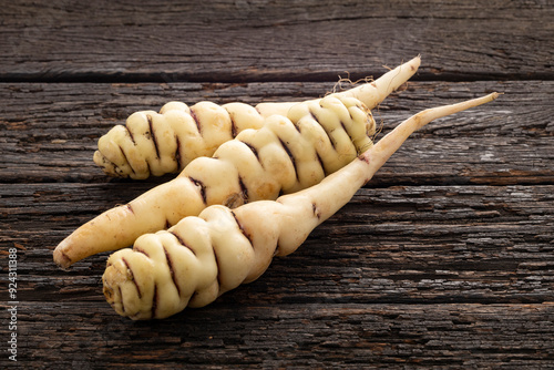 Tropaeolum tuberosum - Colombian organic cubios. Tubers on wooden background. photo