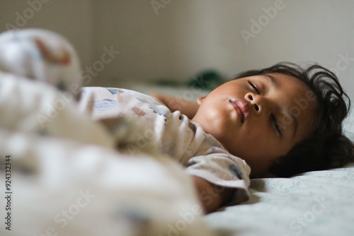 Adorable cute toddler or baby boy sleeping on bed at morning with sweet dream in bedroom Lovely child get deep sleep and get relax and happy during lying down on bed Little infant boy get good sleep