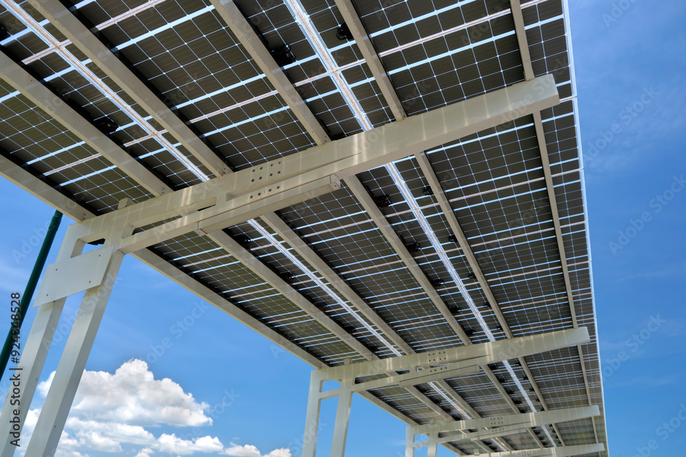 Solar panels installed over parking lot canopy shade for parked cars for effective generation of clean energy Solar panels installed over parking lot canopy shade for parked cars for effective generation of clean energy