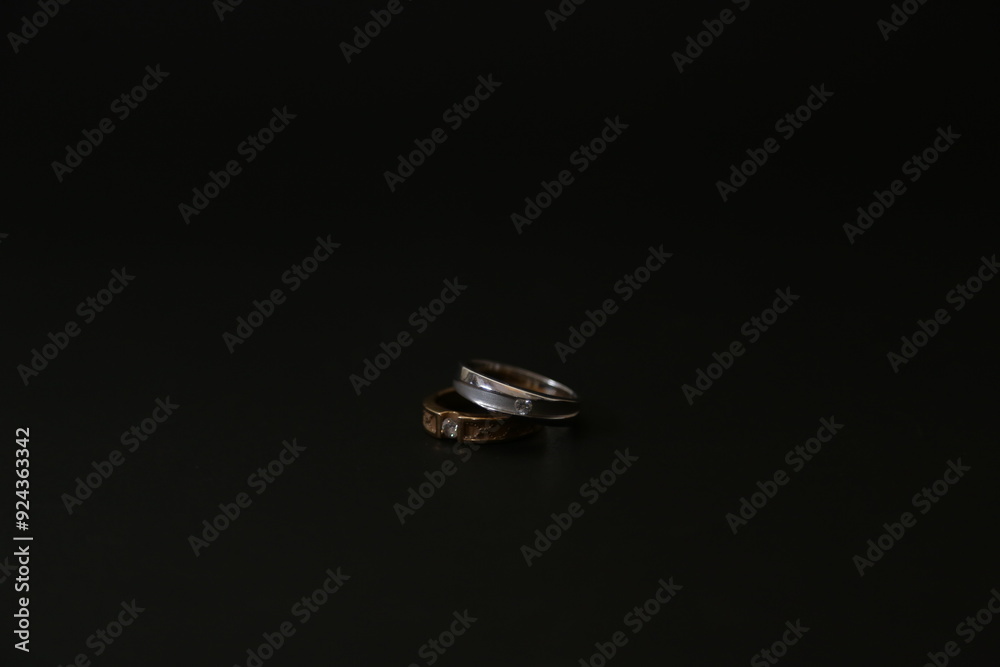 A stunning gold and silver wedding ring set against a black background, highlighting elegance and timeless commitment. A stunning gold and silver wedding ring set against a black background, highlighting elegance and timeless commitment.