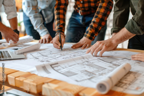 photo Project Planning: Team members gathered around a table with blueprints and plans