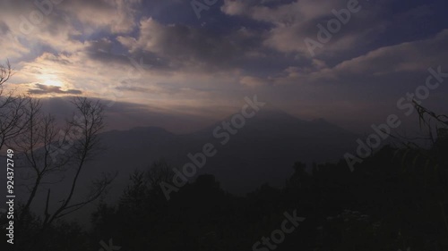 A mountain landscape transitioning from morning to noon, featuring a sunrise and moving clouds, capturing nature's dynamic beauty