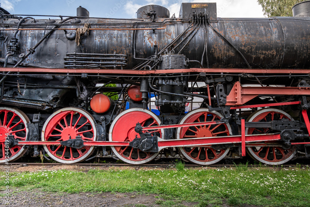 Details of an old rusty steam train wheels and machinery in a serene outdoor setting during daylight Details of an old rusty steam train wheels and machinery in a serene outdoor setting during daylight