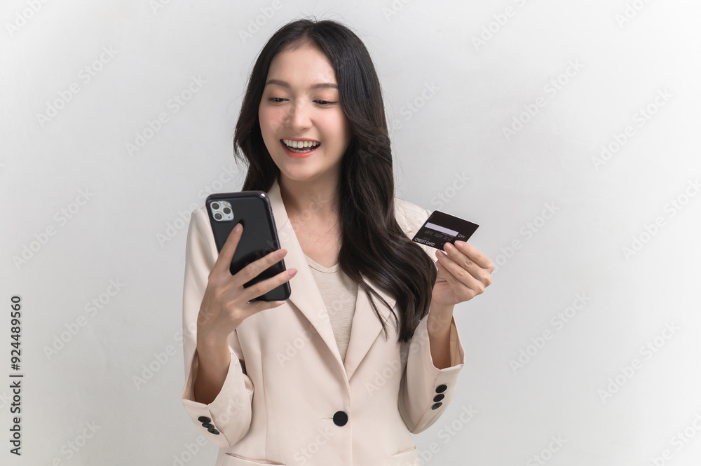 Portrait photo of young beautiful Asian woman feeling happy or surprise shock and looking at smart phone and credit card on white background can use for advertising or product presenting concept. Portrait photo of young beautiful Asian woman feeling happy or surprise shock and looking at smart phone and credit card on white background can use for advertising or product presenting concept.