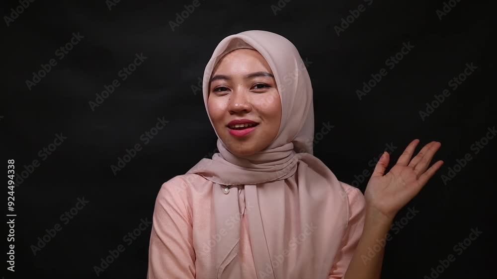 close up of a beautiful Asian Muslim woman with a hijab and pink blouse isolated on a black background studio, Muslim beauty skin care concept.
close up of a beautiful Asian Muslim woman with a hijab and pink blouse isolated on a black background studio, Muslim beauty skin care concept.