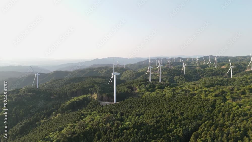 A cluster of wind turbines for generating electric power in a valley surrounded by green forest. wind generator Environmentally sustainable energy concept. Top view from a drone A cluster of wind turbines for generating electric power in a valley surrounded by green forest. wind generator Environmentally sustainable energy concept. Top view from a drone