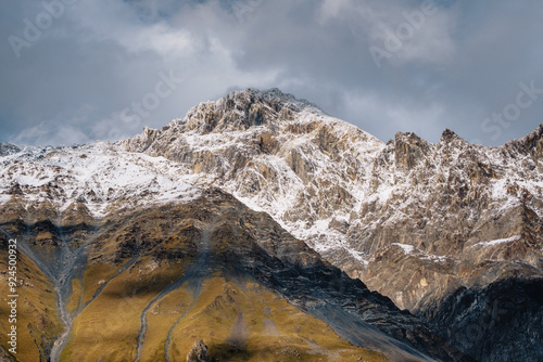 View of the snow-capped peaks of the Caucasus surrounding the village of Stepantsminda in the Kazbegi region of Georgia photo